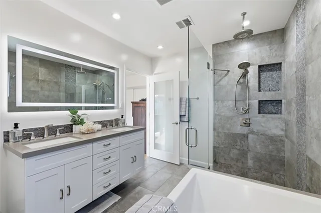 a bathroom with a double vanity sink mirror double and shower