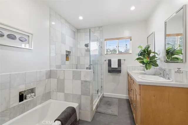 a bathroom with a granite countertop sink a mirror a bathtub and shower