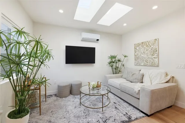a living room with furniture a flat screen tv and a potted plant