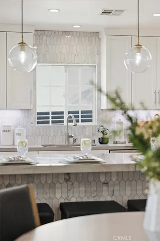 a kitchen with a sink a counter space appliances and cabinets