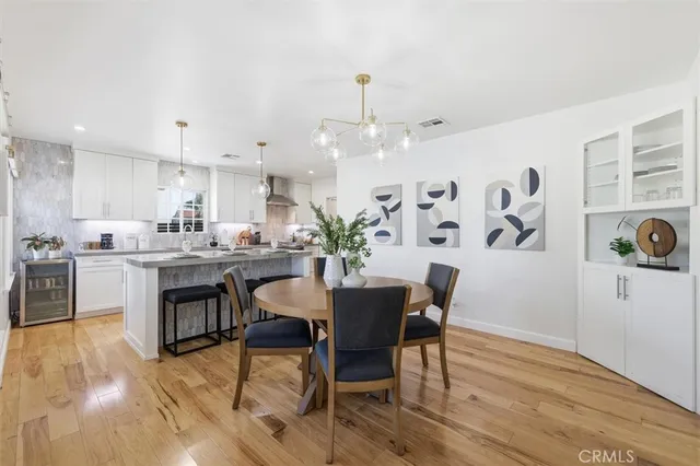a kitchen with a dining table chairs and wooden floor