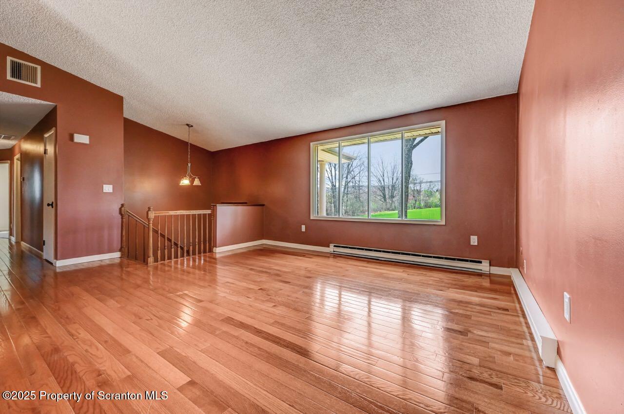 219 Noble Road Clarks Summit, PA 18411 - Photo 11 of 47 a view of an empty room with wooden floor and a window