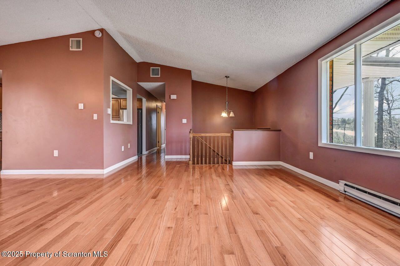 219 Noble Road Clarks Summit, PA 18411 - Photo 12 of 47 a view of an empty room with wooden floor and a window