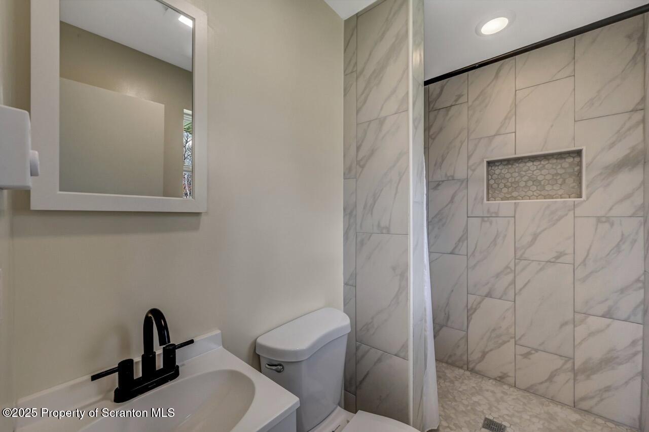 219 Noble Road Clarks Summit, PA 18411 - Photo 21 of 47 a bathroom with a toilet sink and a mirror