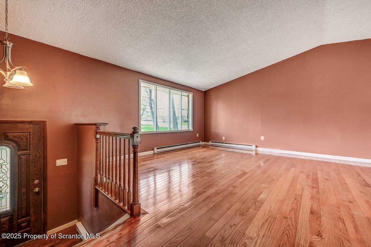 219 Noble Road Clarks Summit, PA 18411 - Photo 10 of 47 an empty room with wooden floor and windows