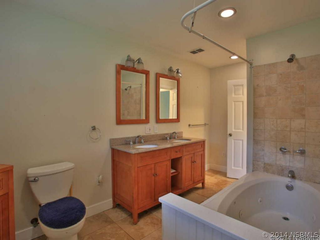 2738 Letha Road New Smyrna Beach, FL 32168 - Photo 13 of 21 a bathroom with a tub a sink and a mirror