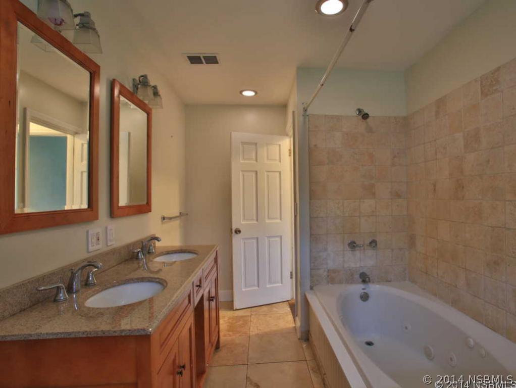 2738 Letha Road New Smyrna Beach, FL 32168 - Photo 14 of 21 a bathroom with a granite countertop sink mirror bathtub and shower