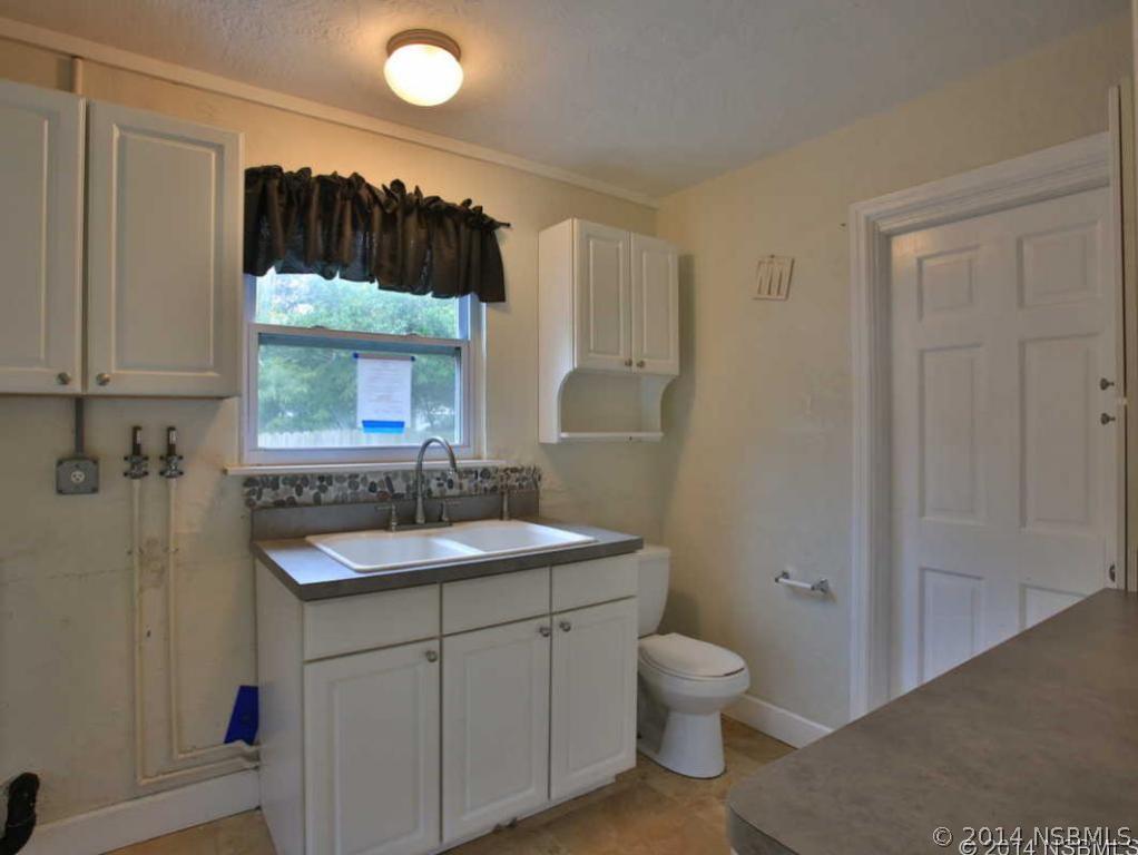 2738 Letha Road New Smyrna Beach, FL 32168 - Photo 19 of 21 a bathroom with a toilet sink vanity granite and shower