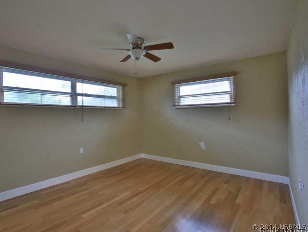 2738 Letha Road New Smyrna Beach, FL 32168 - Photo 10 of 21 a view of empty room with wooden floor and fan