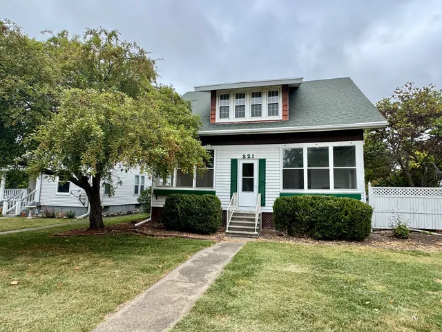 a front view of a house with a yard and trees