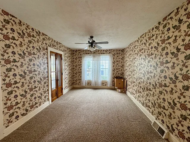 a view of a livingroom with a ceiling fan and window