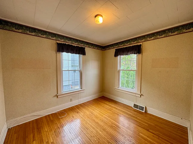 a view of a hallway with wooden floor and stairs