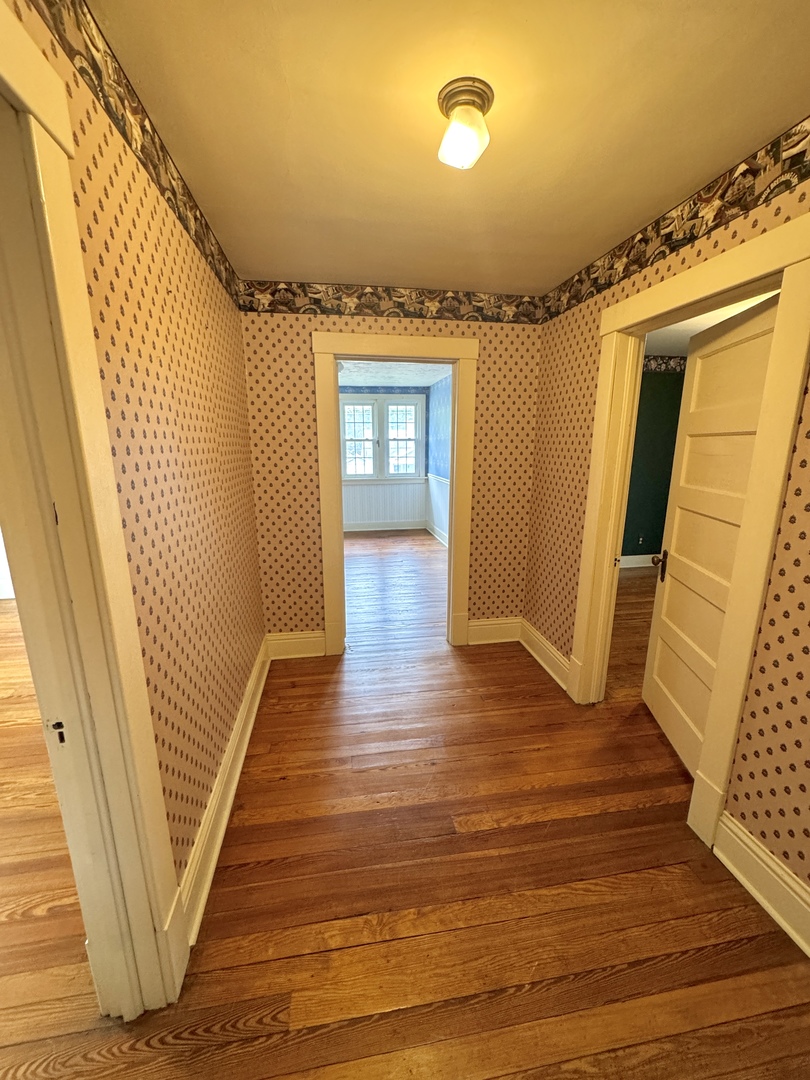 221 West Peru Street Princeton, IL 61356 - Photo 14 of 33 a view of a hallway with wooden floor and stairs