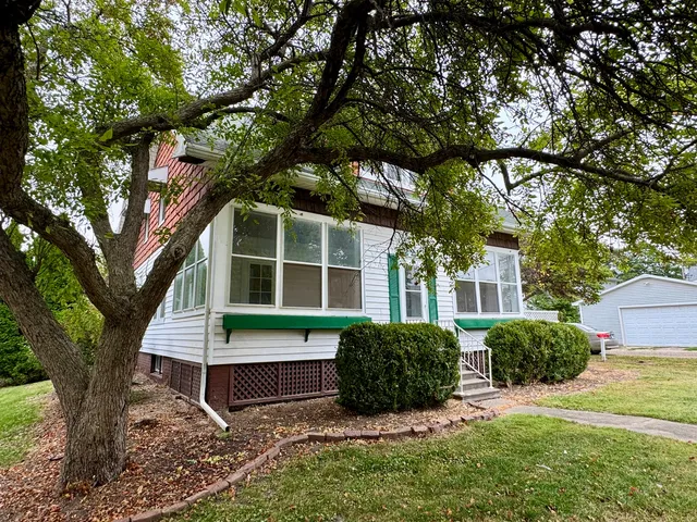 a view of house with backyard and a tree