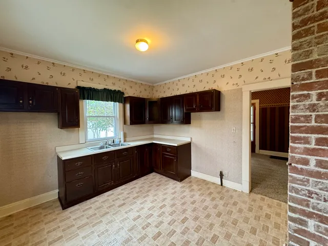 a large kitchen with stainless steel appliances a sink stove and cabinets