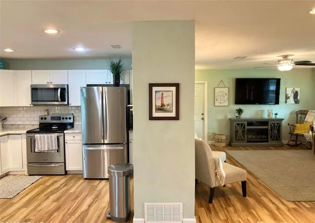 a kitchen with granite countertop a refrigerator stove and microwave