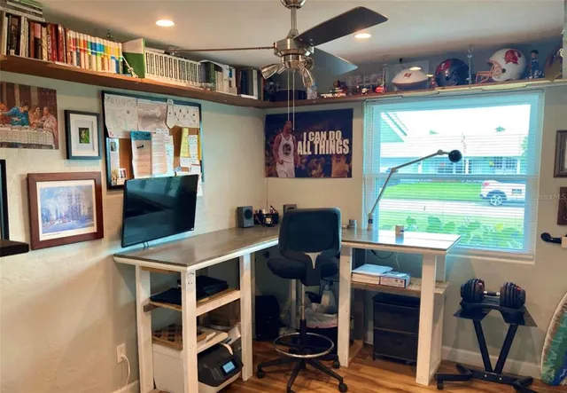 a view of a workspace with furniture and a bookshelf