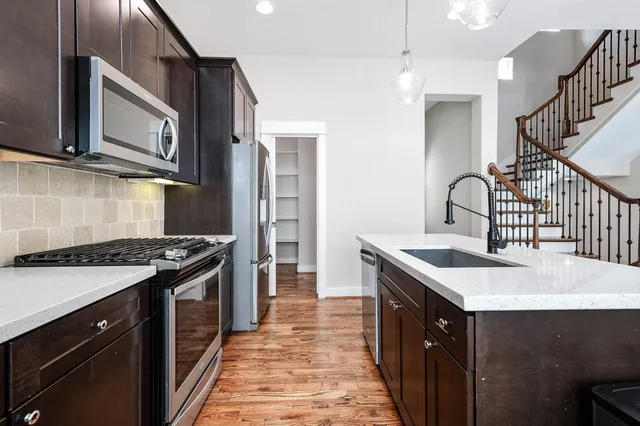 a kitchen with stainless steel appliances granite countertop a sink stove and refrigerator
