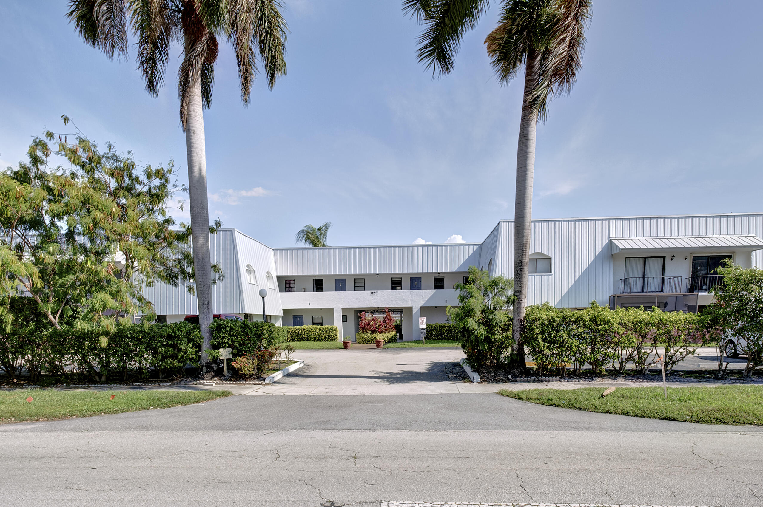 825 Northwest 13th Street, Unit 223 Boca Raton, FL 33486 - Photo 22 of 42 a front view of a house with a garden and a yard