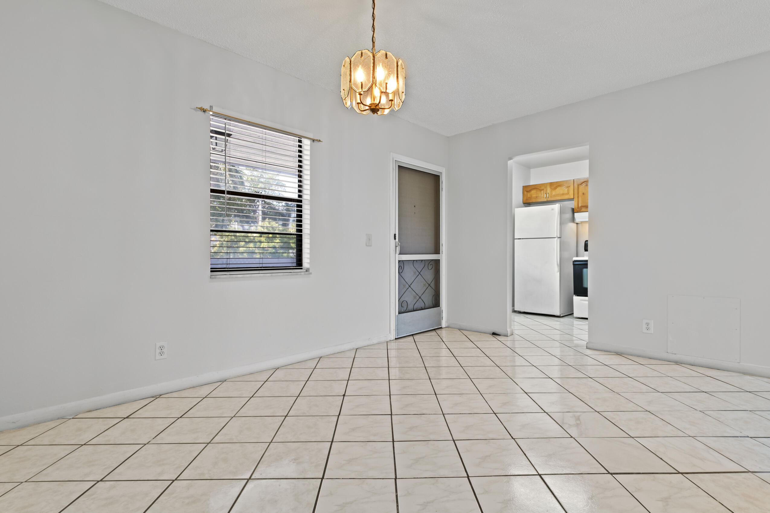 825 Northwest 13th Street, Unit 223 Boca Raton, FL 33486 - Photo 32 of 42 a view of an empty room with window and chandelier fan