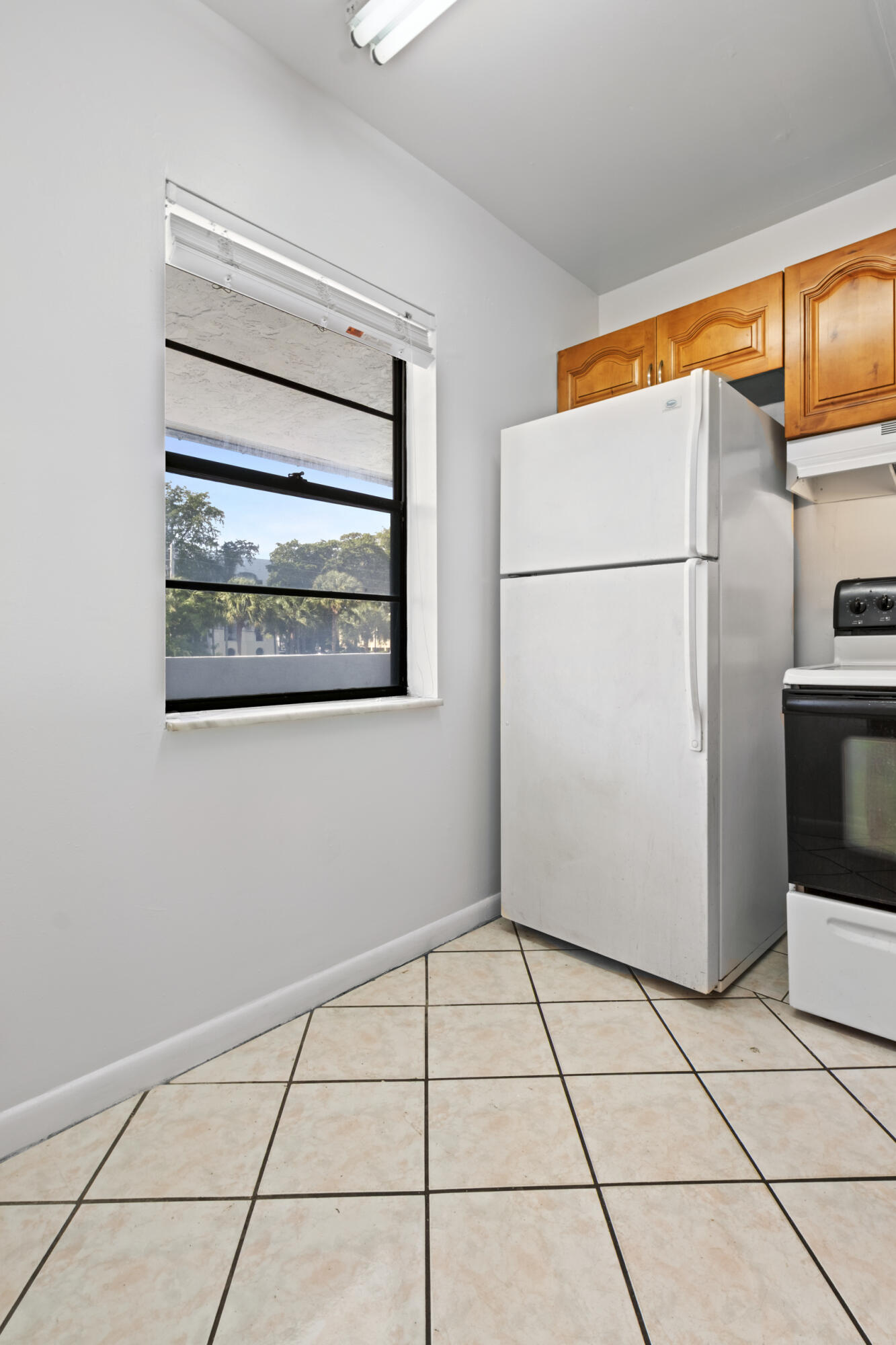 825 Northwest 13th Street, Unit 223 Boca Raton, FL 33486 - Photo 40 of 42 a view of a refrigerator in kitchen and an empty room