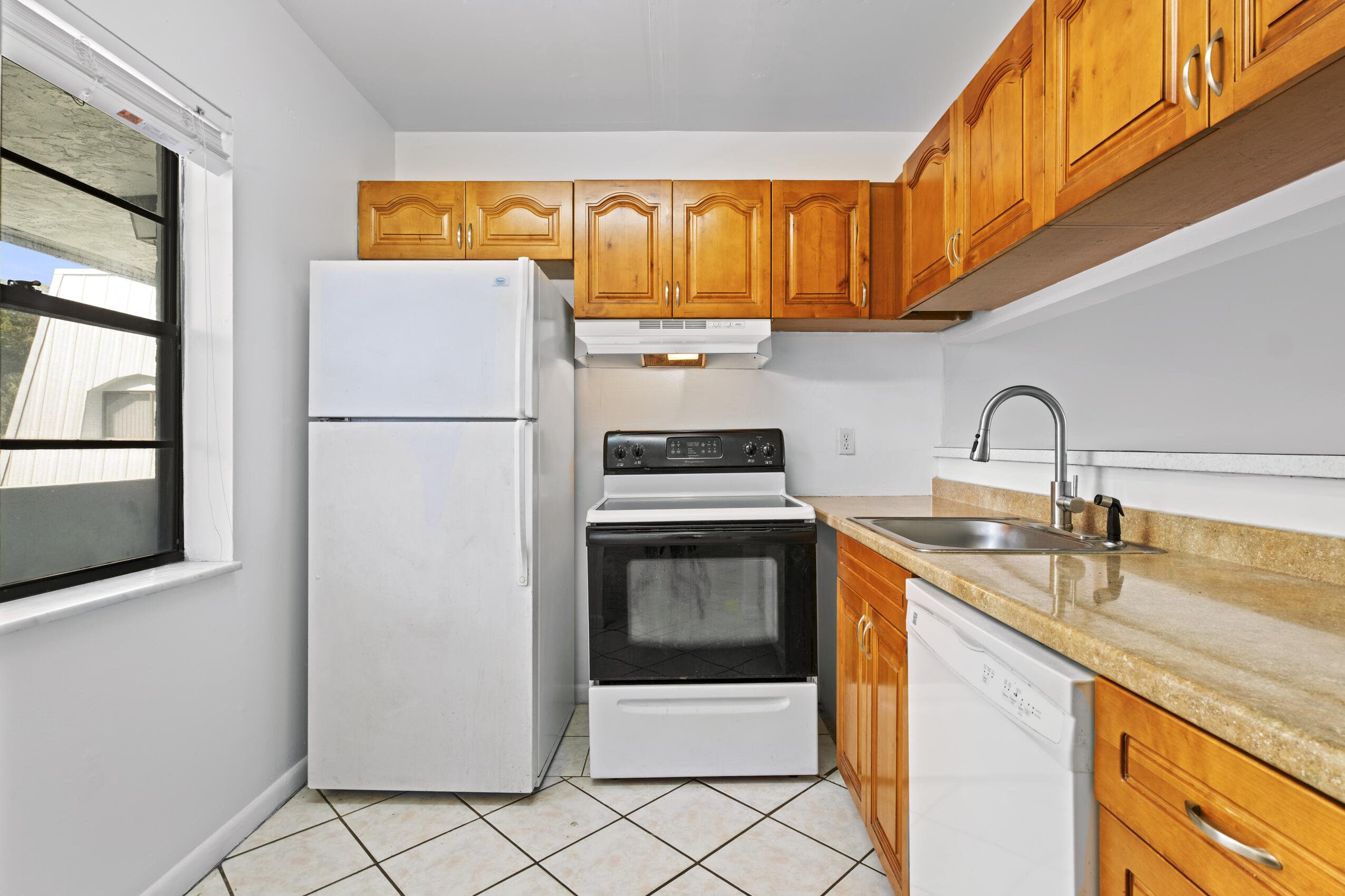 825 Northwest 13th Street, Unit 223 Boca Raton, FL 33486 - Photo 7 of 42 a kitchen with a sink a refrigerator and cabinets