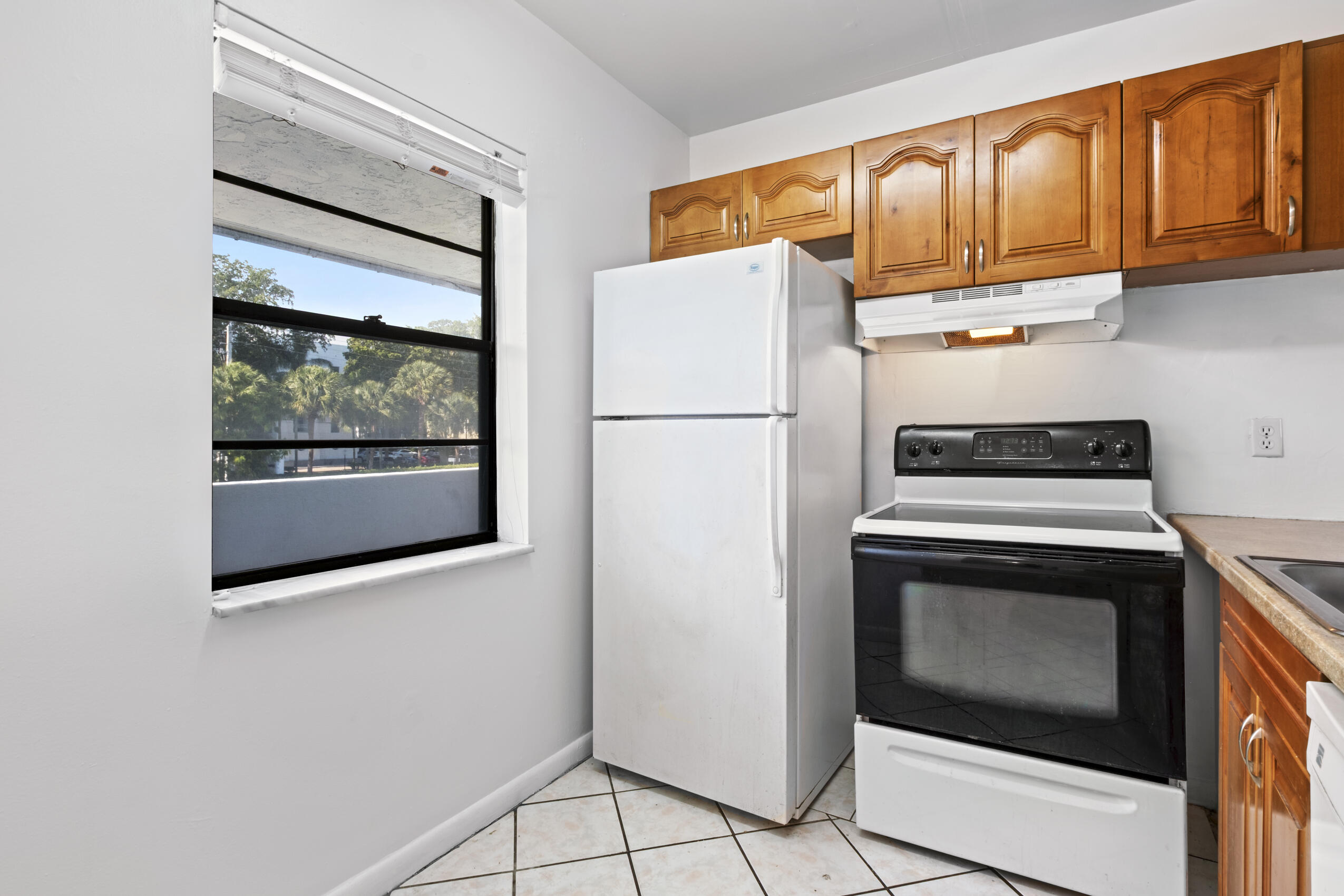 825 Northwest 13th Street, Unit 223 Boca Raton, FL 33486 - Photo 10 of 42 a white refrigerator freezer and a stove sitting inside of a kitchen