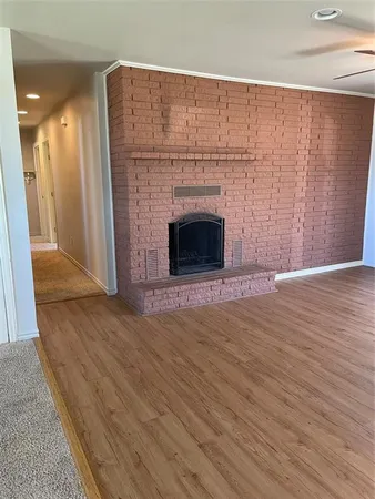 a view of empty room with wooden floor and fireplace
