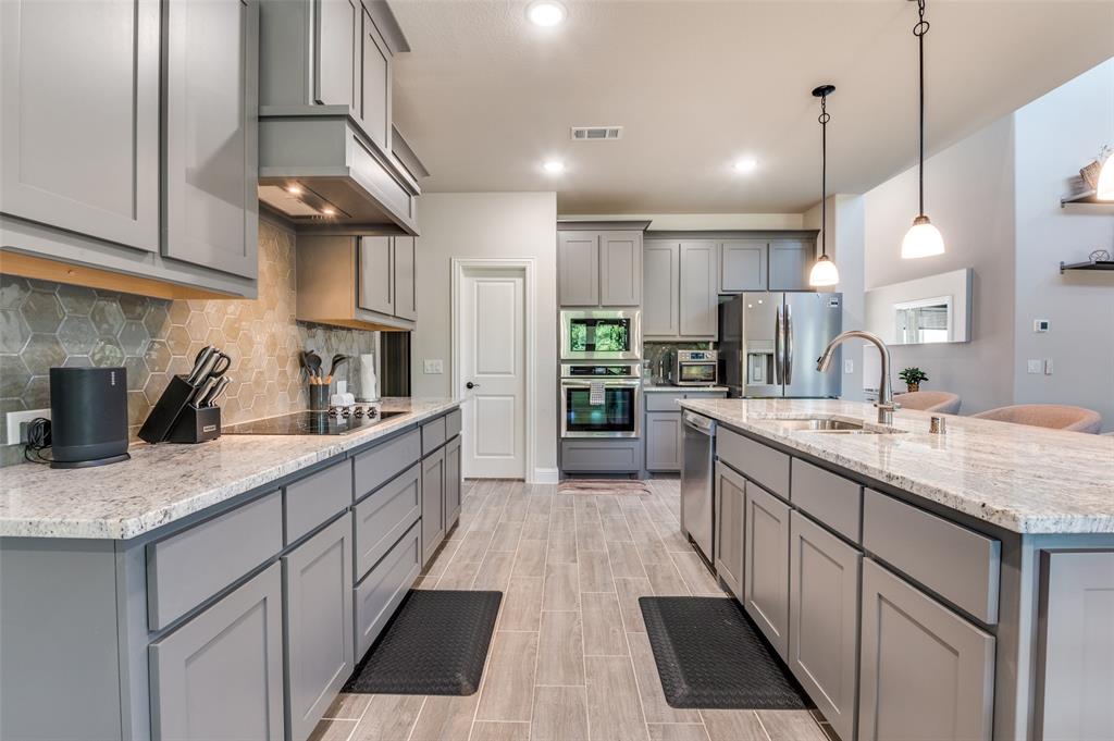 4810 Nomad Drive Midlothian, TX 76065 - Photo 13 of 39 a kitchen with stainless steel appliances granite countertop a sink a stove and a refrigerator