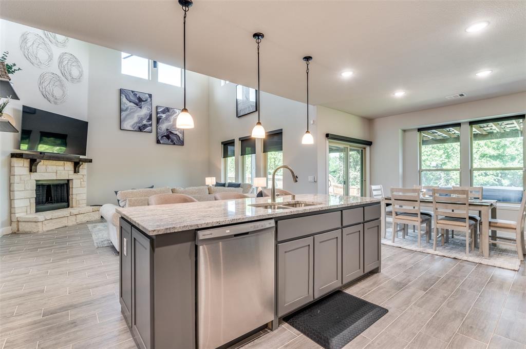 4810 Nomad Drive Midlothian, TX 76065 - Photo 39 of 39 a kitchen with kitchen island granite countertop a sink a counter space appliances and cabinets