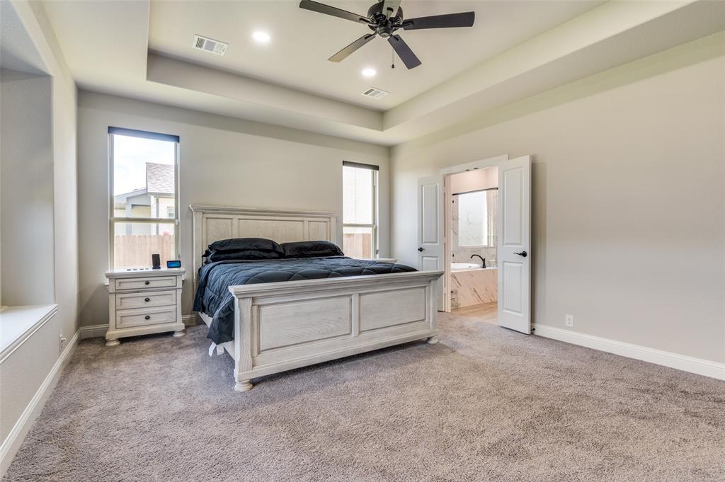 4810 Nomad Drive Midlothian, TX 76065 - Photo 24 of 39 a spacious bedroom with a bed and a chandelier