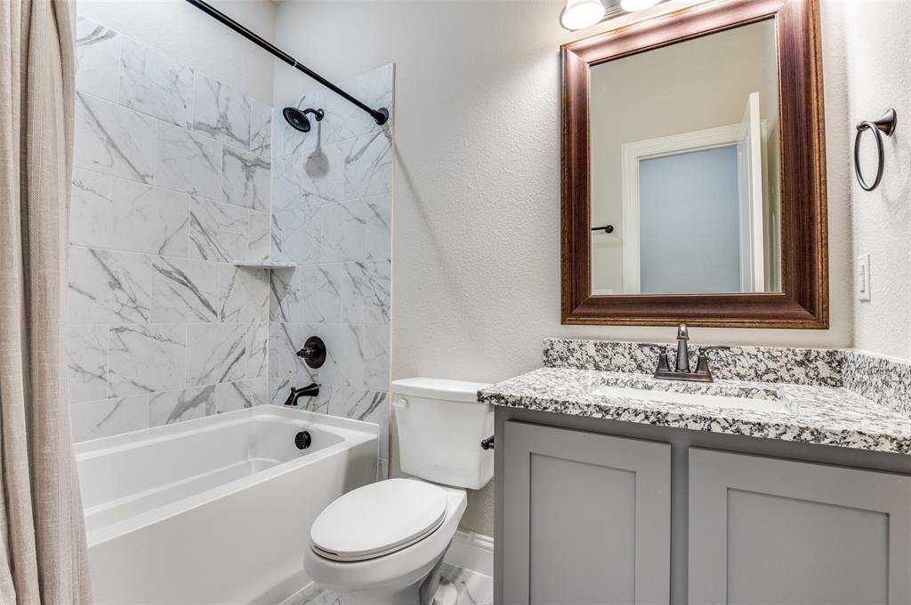 4810 Nomad Drive Midlothian, TX 76065 - Photo 33 of 39 a bathroom with a granite countertop sink toilet vanity mirror bathtub and shower