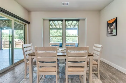 a view of a dining room with furniture large windows and wooden floor