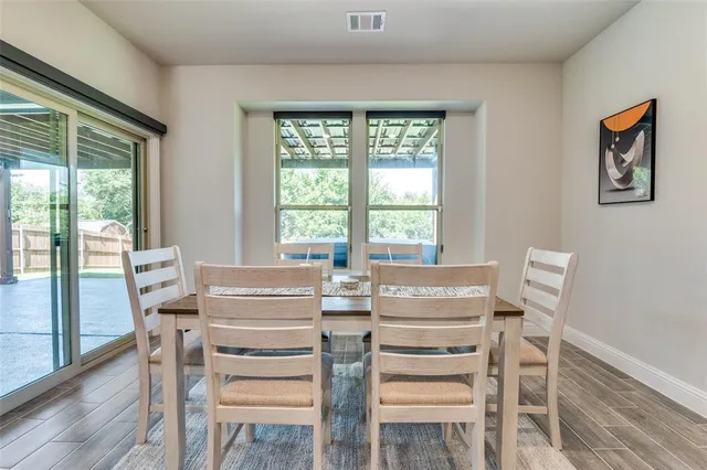 a view of a dining room with furniture large windows and wooden floor