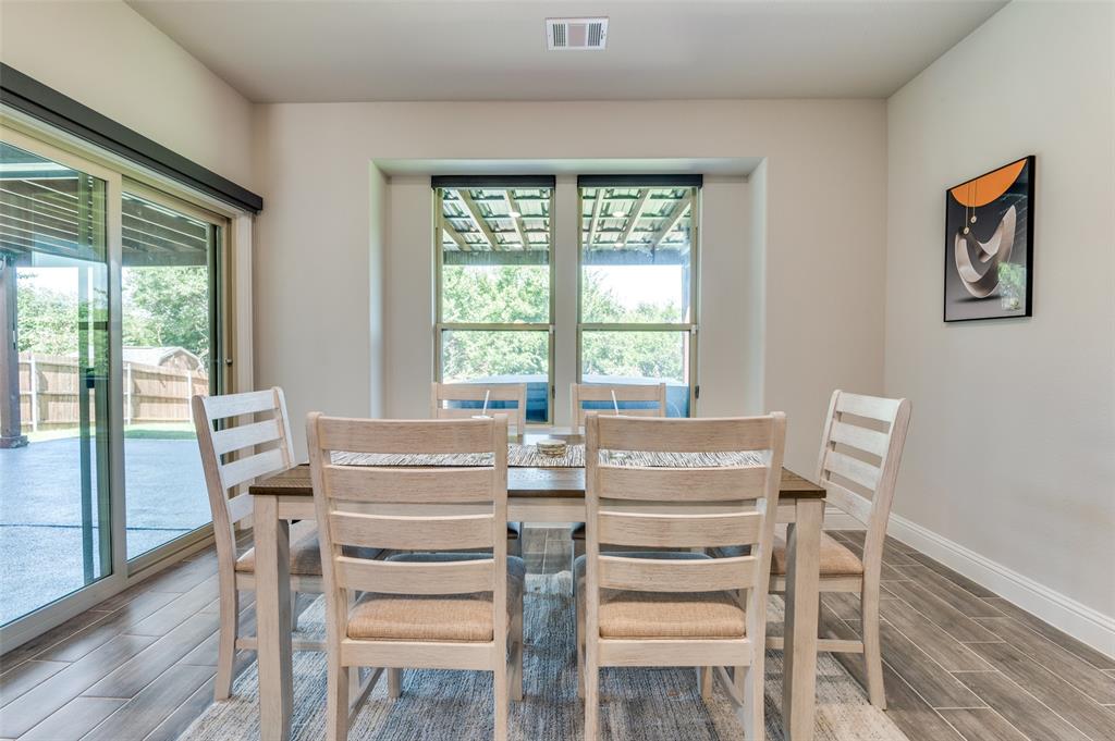 4810 Nomad Drive Midlothian, TX 76065 - Photo 10 of 39 a view of a dining room with furniture large windows and wooden floor