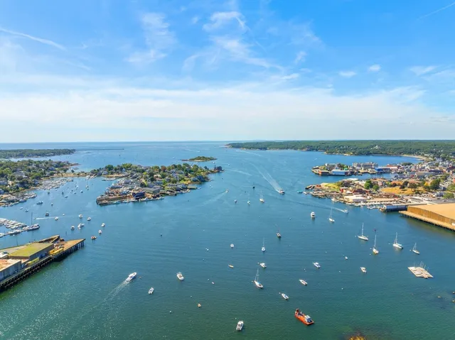 an aerial view of a houses with a ocean view in back