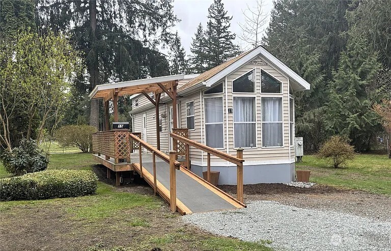 a view of house with a yard and large trees