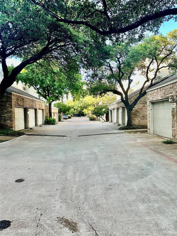 7340 Skillman Street, Unit 405 Dallas, TX 75231 - Photo 18 of 18 Paved driveway bordered by mature trees and brick-clad structures