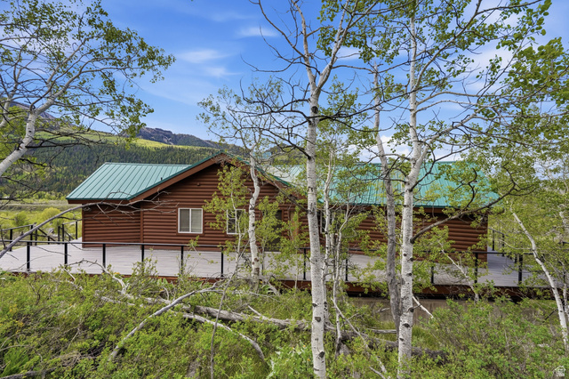 6 Beaver Springs Rancheros Oakley, UT 84055 - Photo 44 of 68 Log cabin exterior with a green metal roof, surrounded by mature trees
