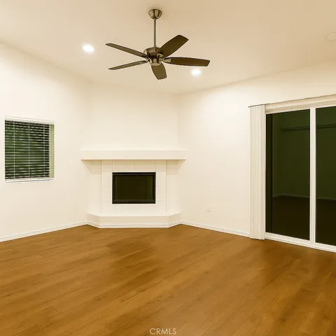 a view of a big room with wooden floor and a ceiling fan