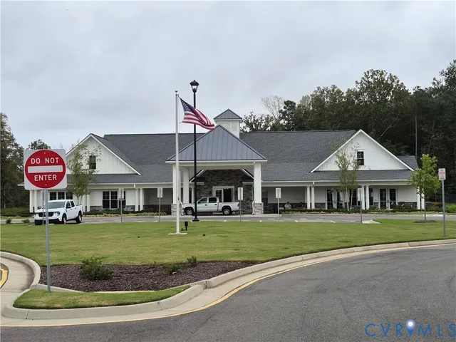 a view of a white house with a big yard and potted plants