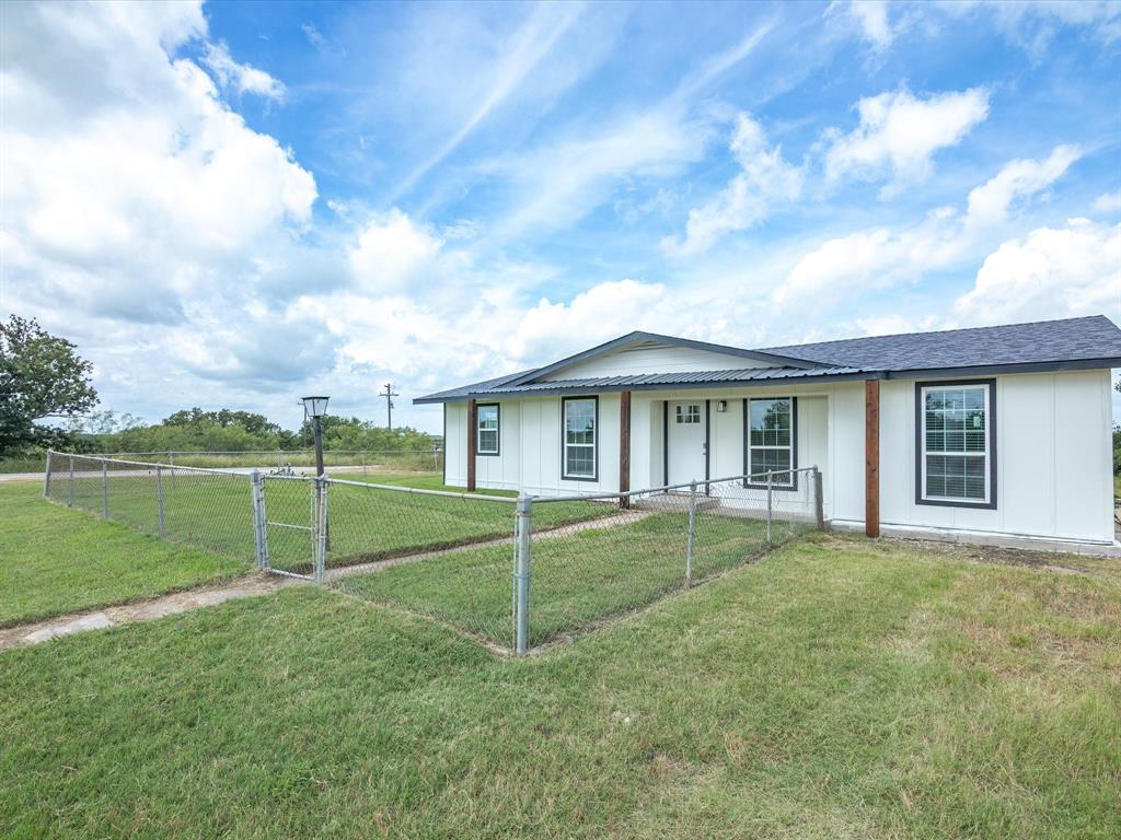 526 Jack Grace Hill Road Bowie, TX 76230 - Photo 26 of 34 a view of a brick house with a big yard and large trees