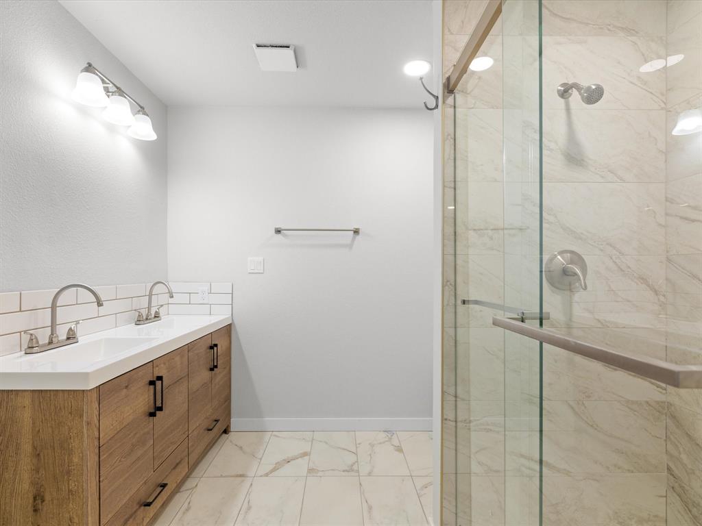 526 Jack Grace Hill Road Bowie, TX 76230 - Photo 6 of 34 a bathroom with a double vanity sink a mirror and shower