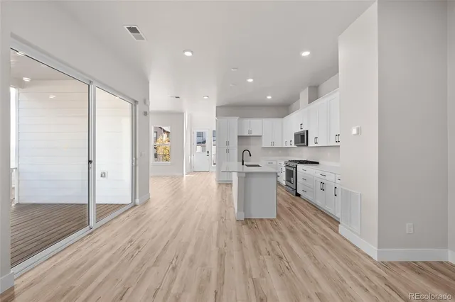 a kitchen with sink stove and refrigerator