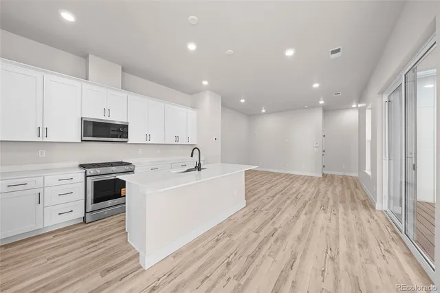 a kitchen with white cabinets and stainless steel appliances