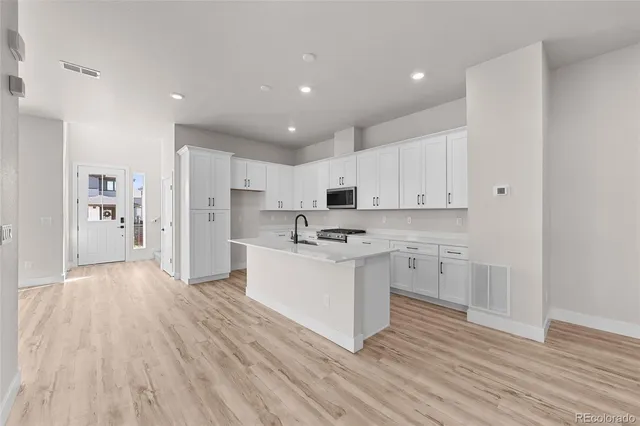 a large kitchen with a lot of counter space and stainless steel appliances