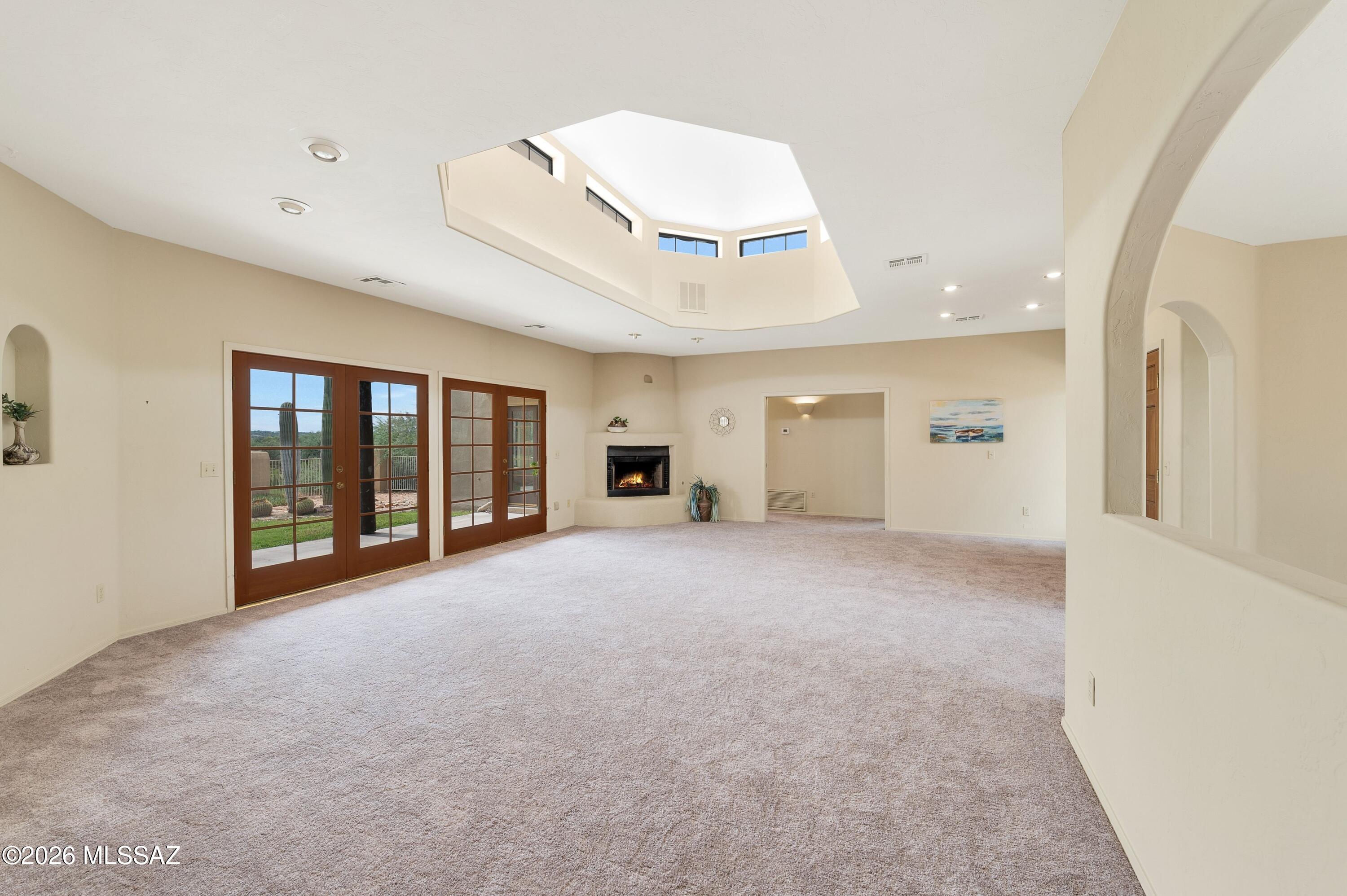 12160 East Tanque Verde Road Tucson, AZ 85749 - Photo 43 of 53 Corner kiva fireplace, French doors, and a display niche off the entry hall.