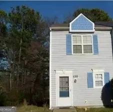 a view of a brick house next to a yard