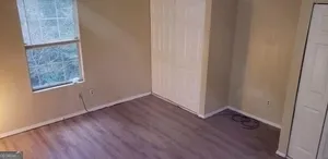 a view of a room with wooden floor and a window