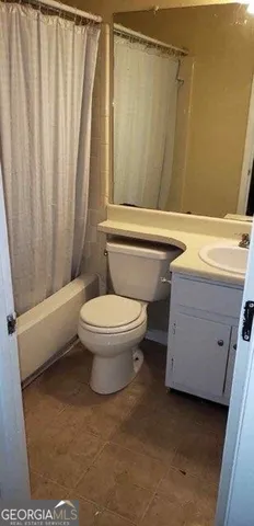 a bathroom with a toilet and a shower curtain